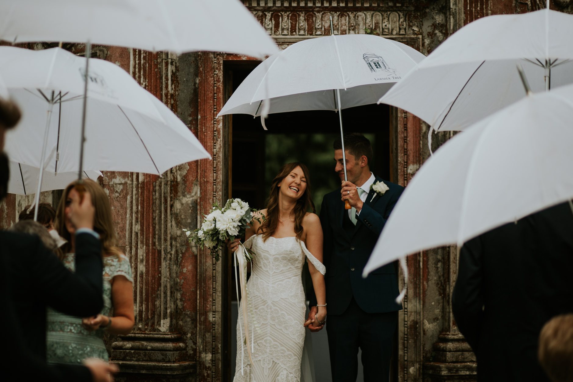 A confetti shot under unbrellas at a Larmer Tree wedding