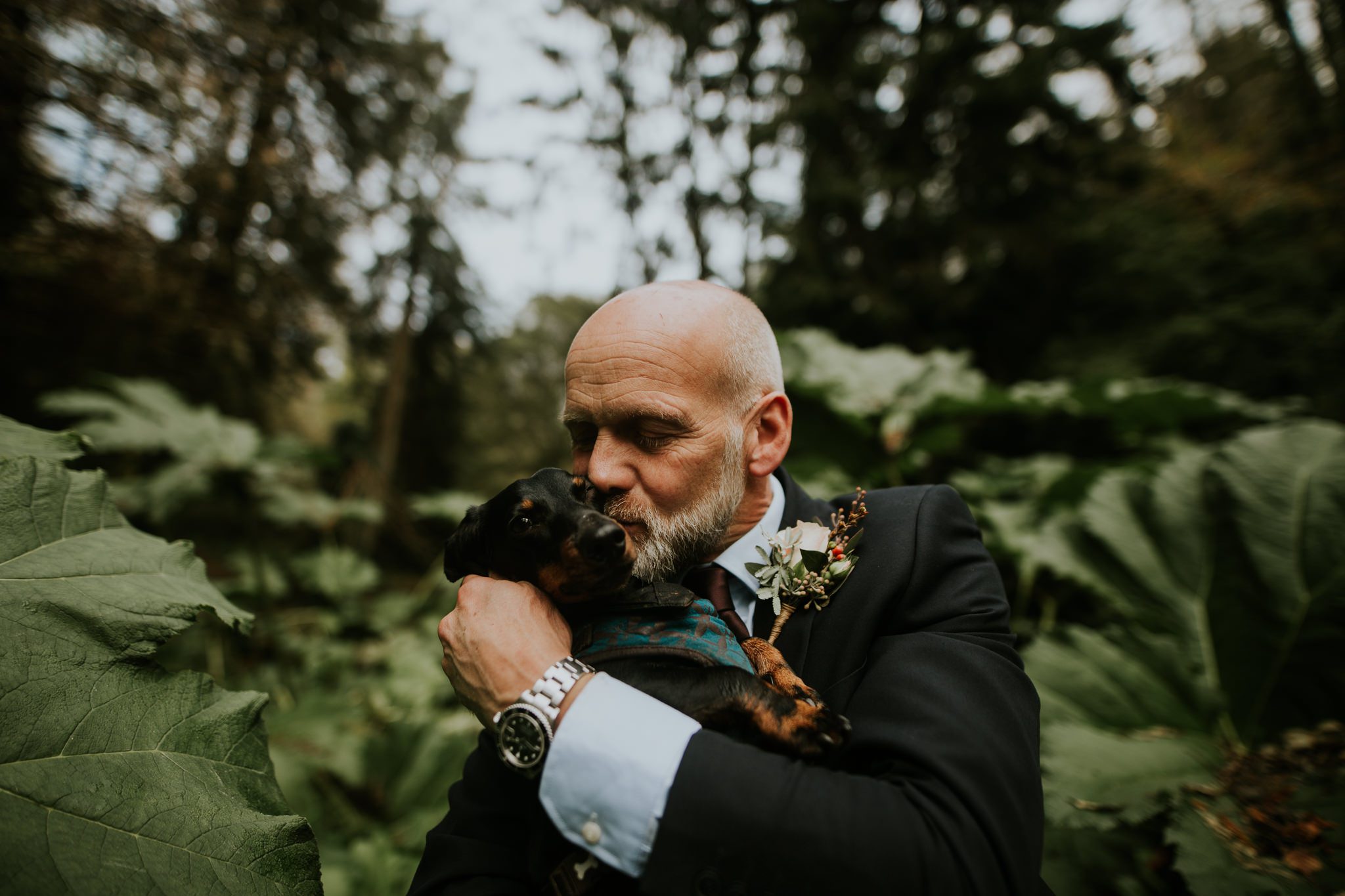 The groom with his dog post in the woods of Hotel Endsleigh