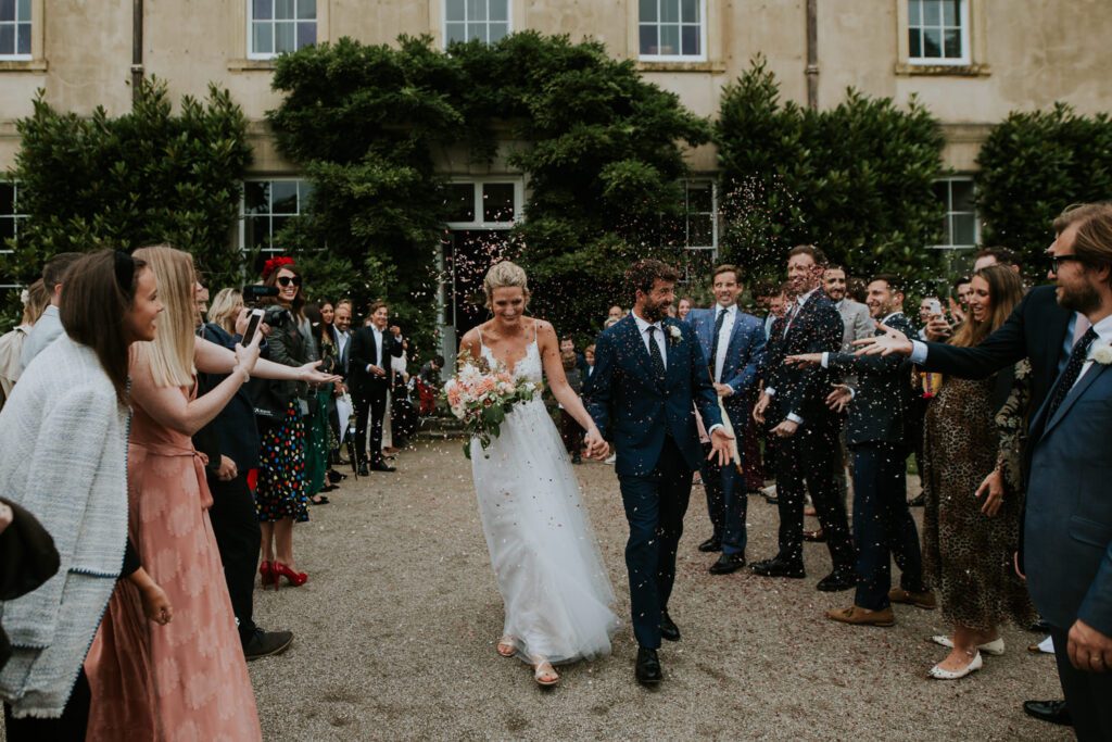 Bride. groom and confetti after a wedding at Pencarrow House in Cornwall