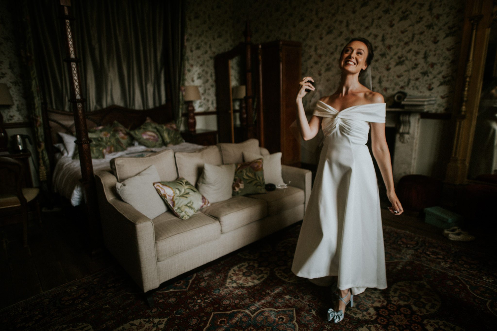 A bride sprays perfume when getting ready for her Devon wedding