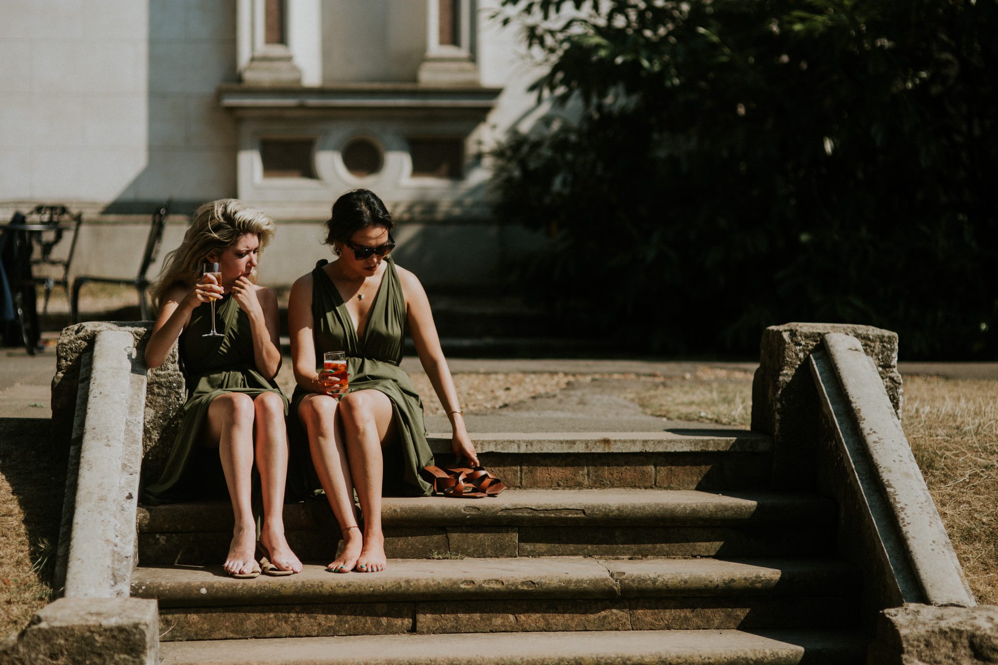 Bridesmaids relax with wine after at wedding ceremony at Hampton Court House in London