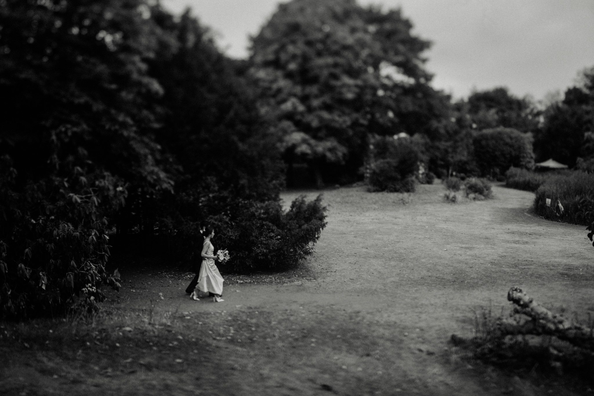 A bride and groom walk the grounds at Hampton Court House in London