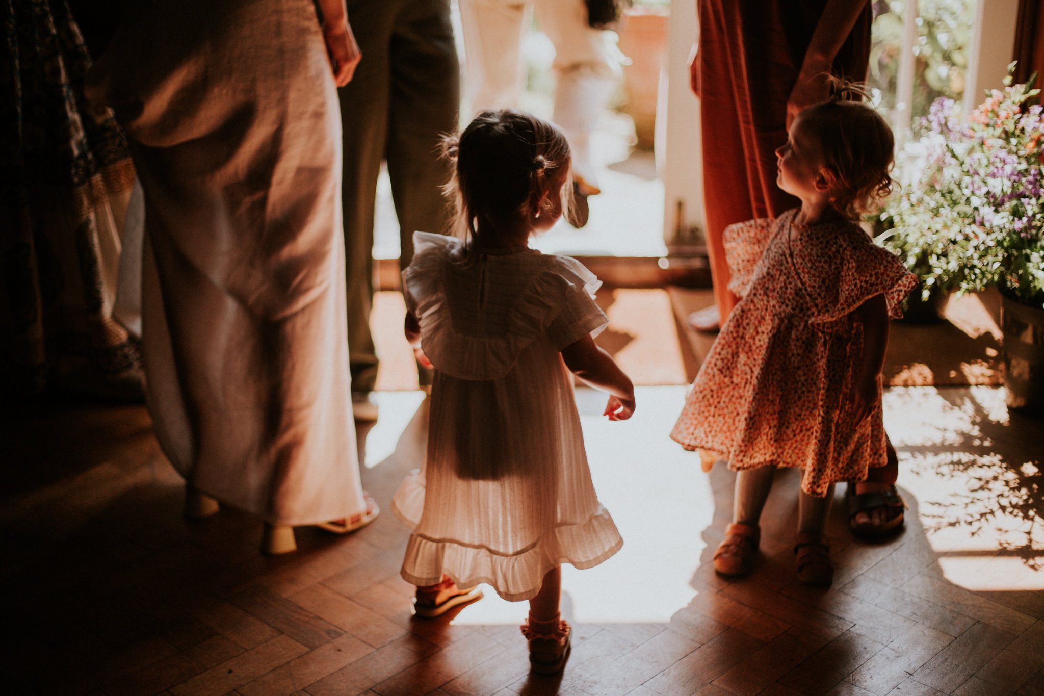 Little girls dance in the sunlight at a wedding at the Lost Music Room, Great Ambrook, Devon