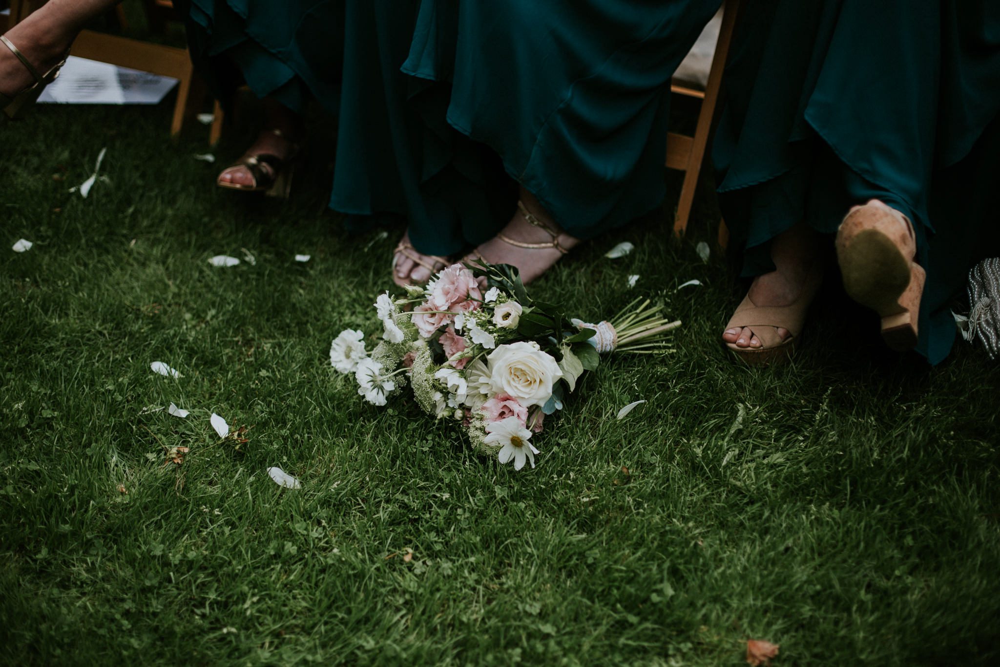 A bridesmaid's bouquet lies on the floor at a wedding