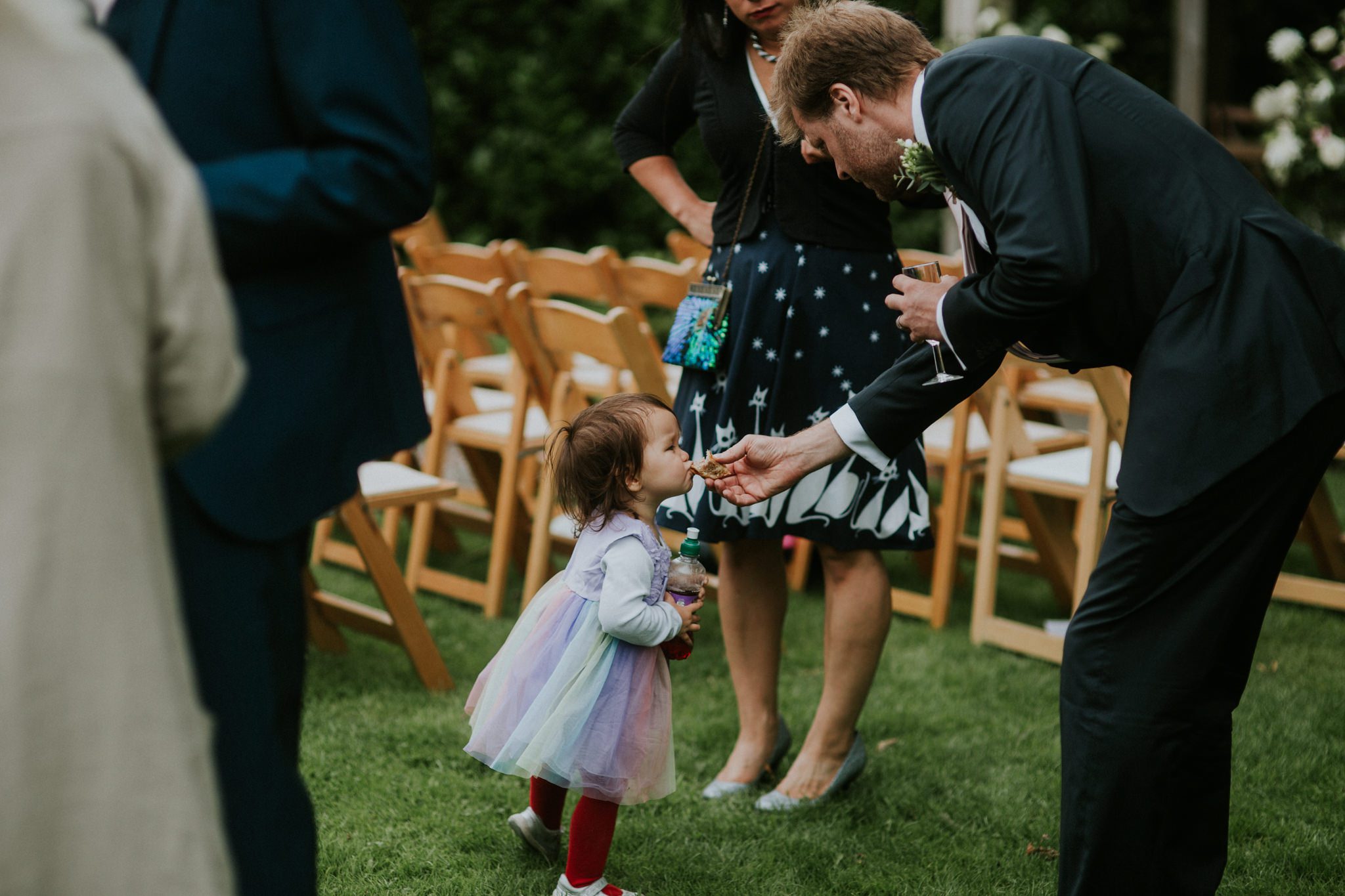 A young wedding guest is fed canapes after a wedding ceremony at Trevenna Barns in Cornwall