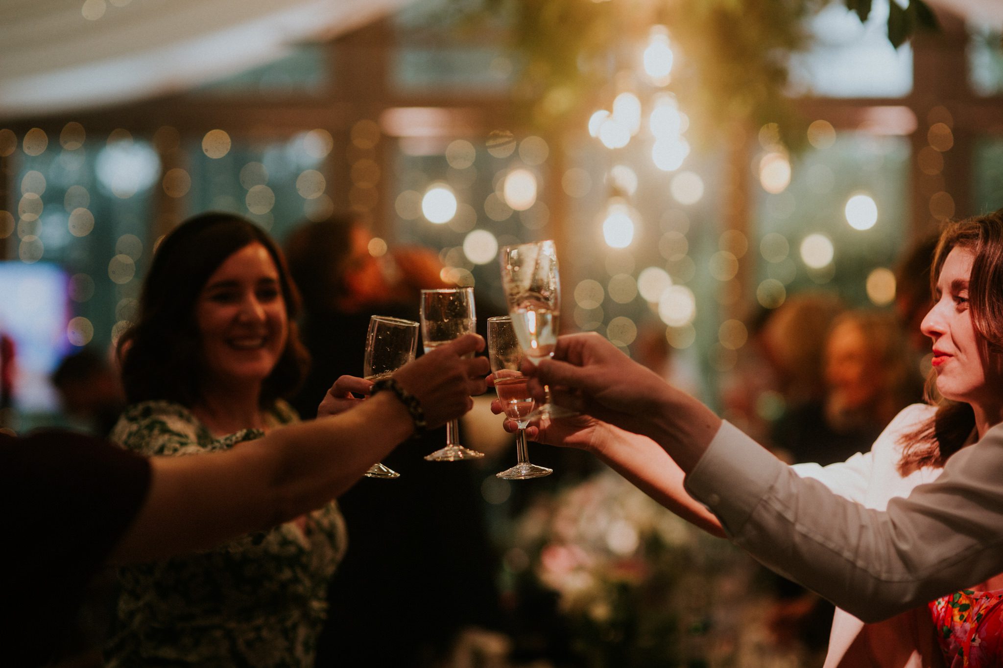 Happy guests toast the bride and groom during wedding reception at Trevenna Barns in Cornwall