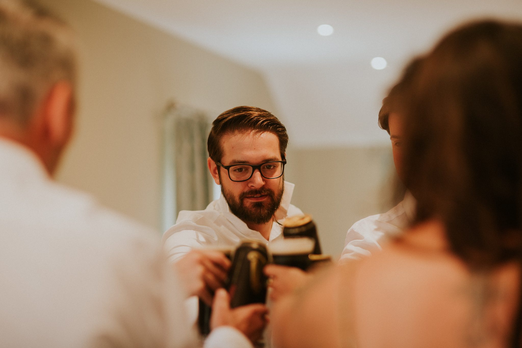 A groom toasts with his friends before his wedding at Upthorne Wood in Suffolk
