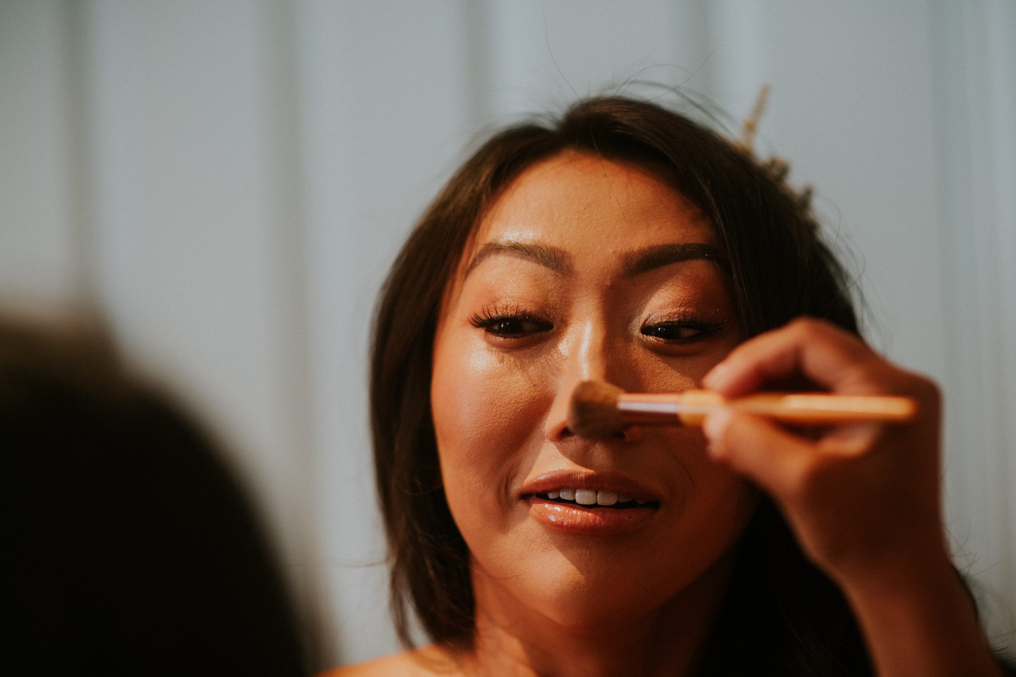 Final touches of make up are applied before a wedding at Upthorne Wood in Suffolk