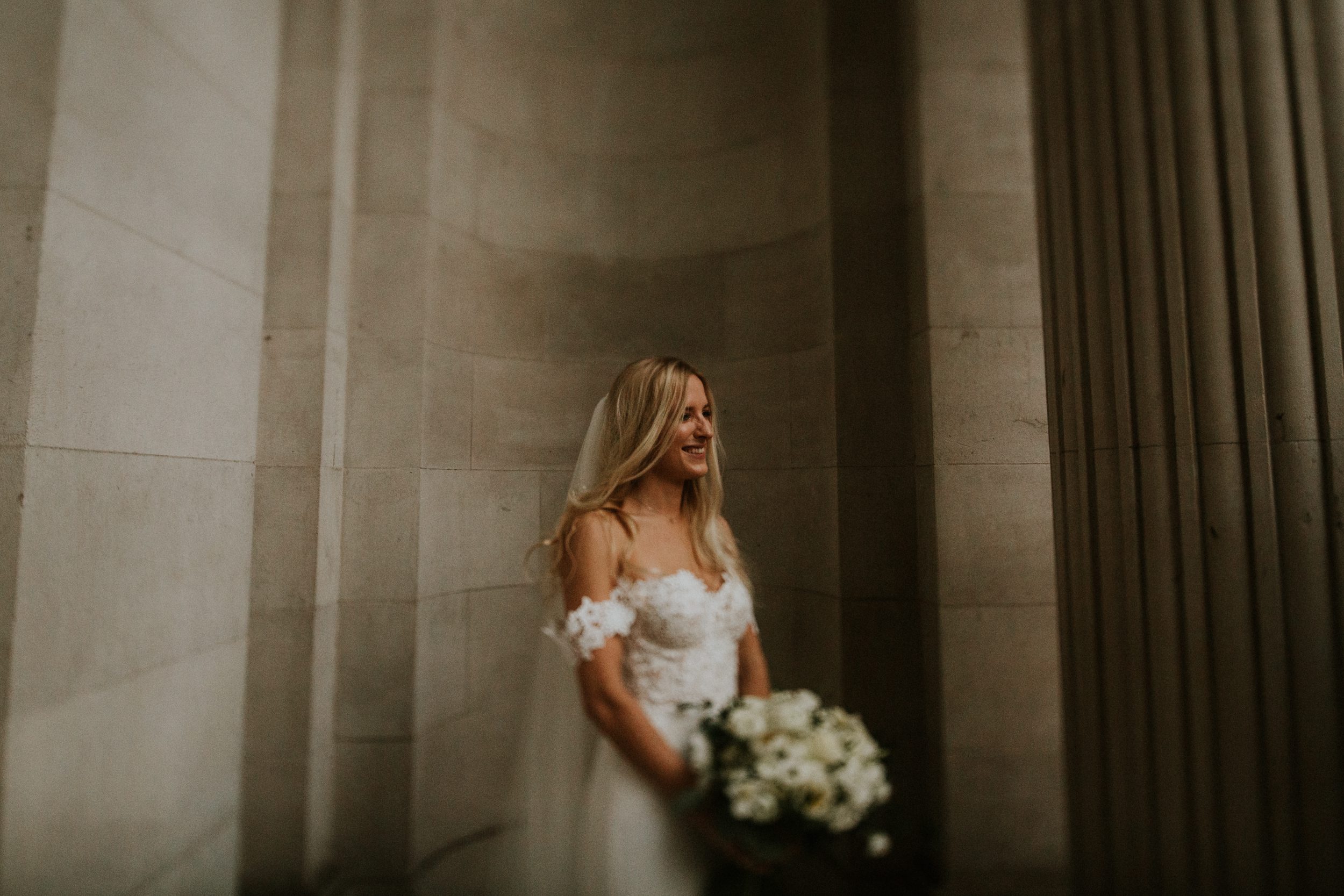 A happy bride poses for a photo after her wedding ceremony at Old Marylebone Town Hall, London