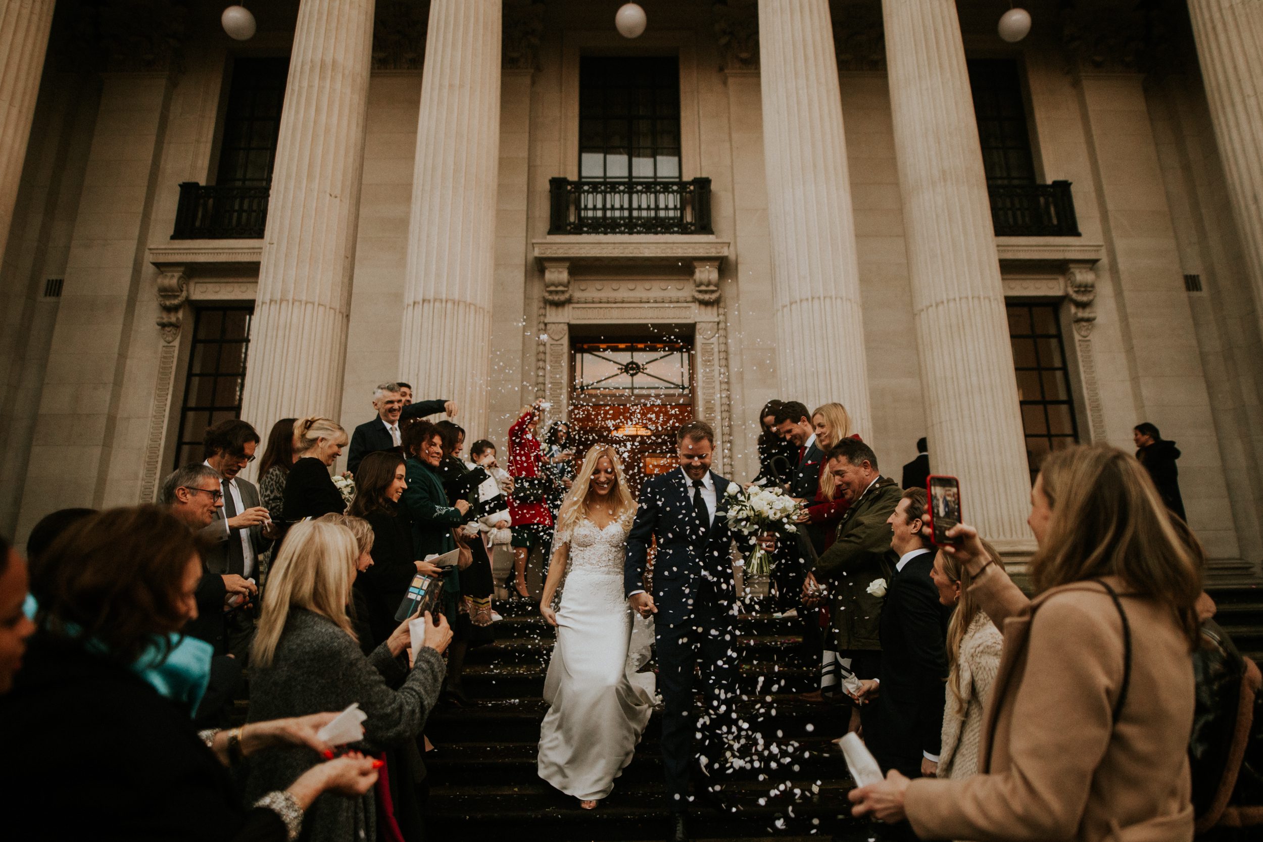 Well wishers shower a bride and groom with confetti as they leave their wedding at Old Marylebone Town Hall. Old Marylebone Town Hall wedding photography