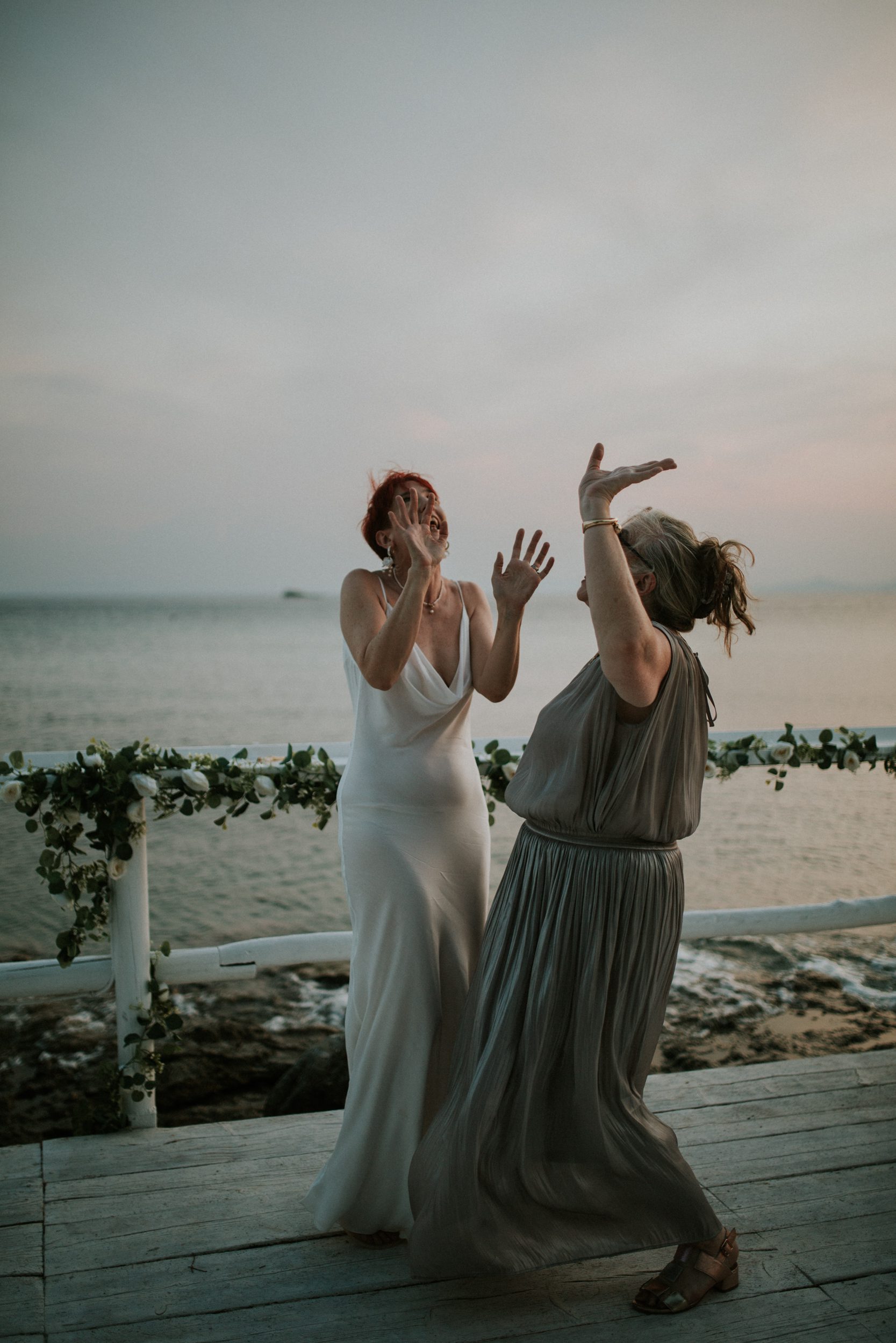 A bride dances with her sister at her wedding on the Athenian Coast in Greece