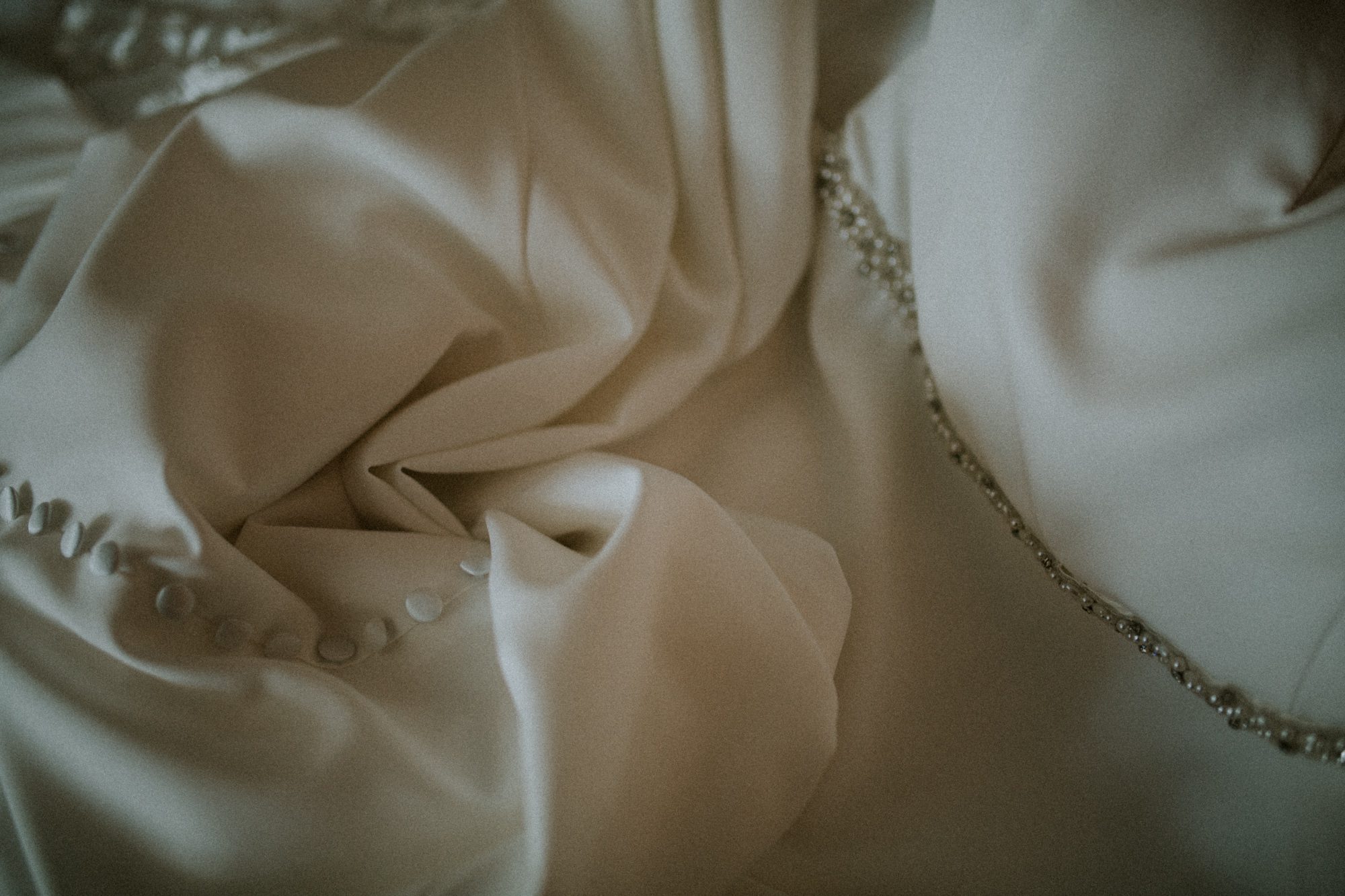 A detail shot of a wedding dress, showing movement and texture