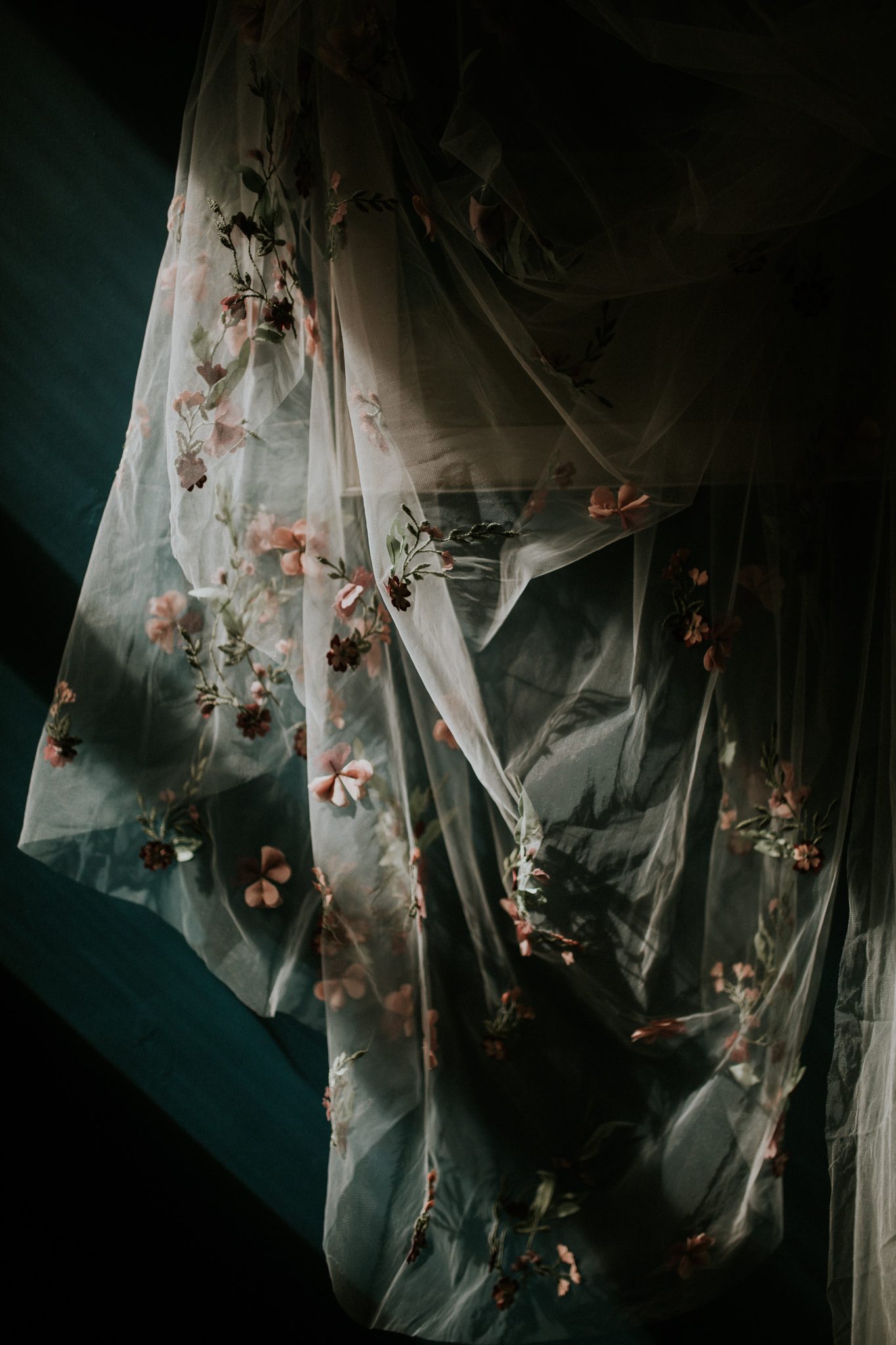 A detail shot of a wedding veil lit dramatically by window light at Scorrier House in Cornwall