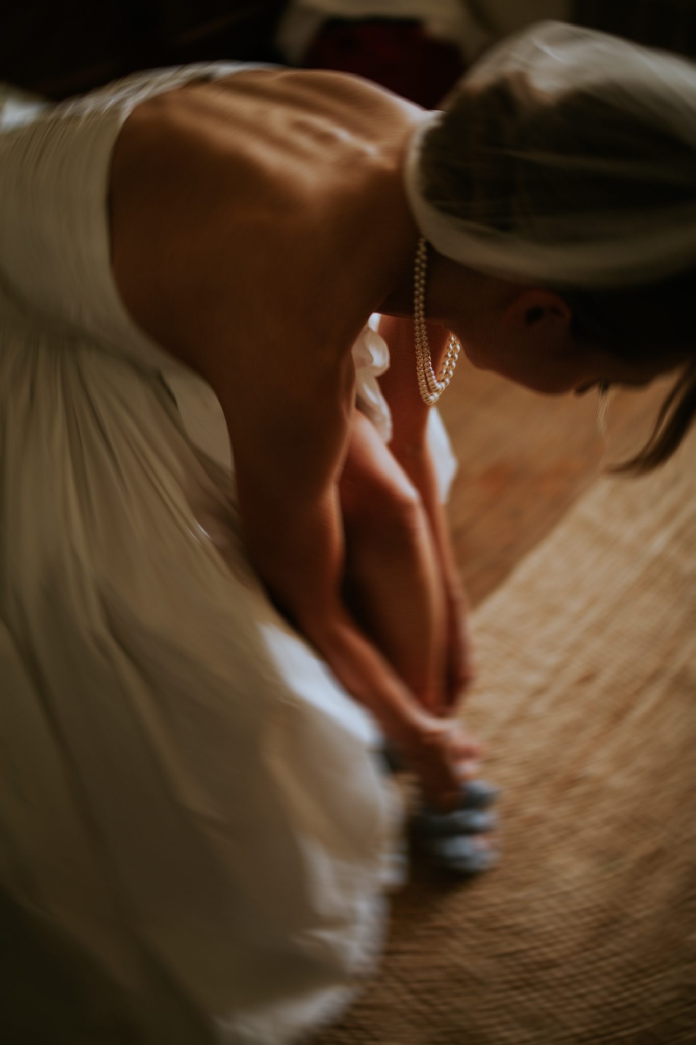 A bride puts on the shoes before her wedding at The Lost Music Hall at Great Ambrook in Devon