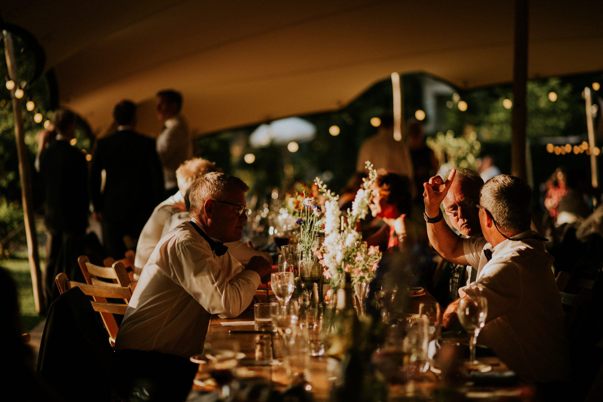 Wedding guests chat and enjoy their food at a wedding at The Lost Music Hall at Great Ambrook in Devon
